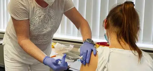 Dr Stefanie Wiesenhütter, part of the vaccination team led by Dr Bernd Wiesenhütter, the company doctor at MC-Bauchemie, vaccinates a wife of an MC-Bauchemie employee.