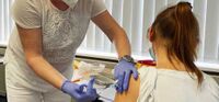 Dr Stefanie Wiesenhütter, part of the vaccination team led by Dr Bernd Wiesenhütter, the company doctor at MC-Bauchemie, vaccinates a wife of an MC-Bauchemie employee.