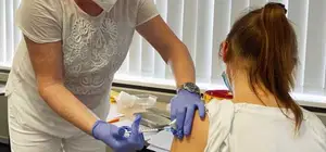 Dr Stefanie Wiesenhütter, part of the vaccination team led by Dr Bernd Wiesenhütter, the company doctor at MC-Bauchemie, vaccinates a wife of an MC-Bauchemie employee.