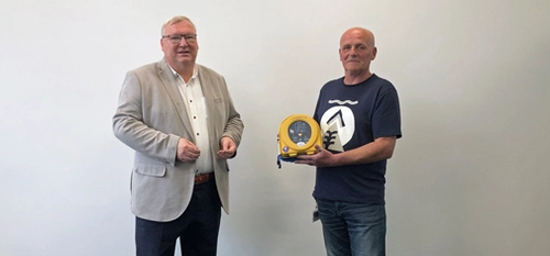 Hans-Peter Marten (left) presents MC security guard Mieczyslaw Pacanowski (right) with a defibrillator. 